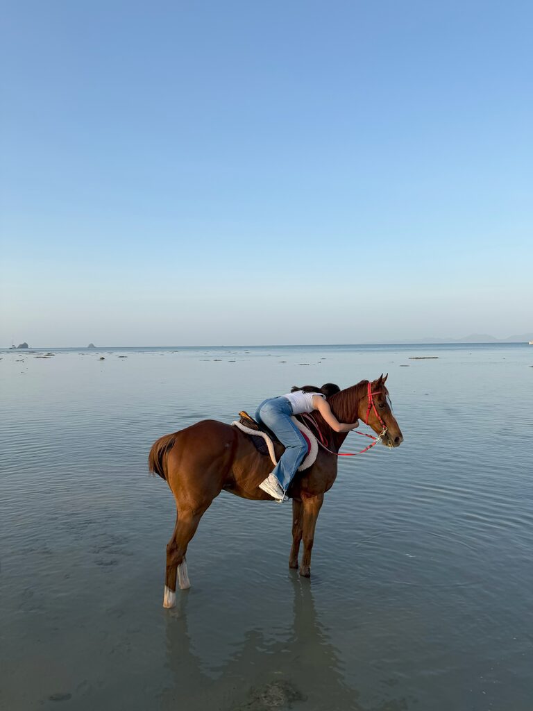 Ale Garces hugging a horse by the water